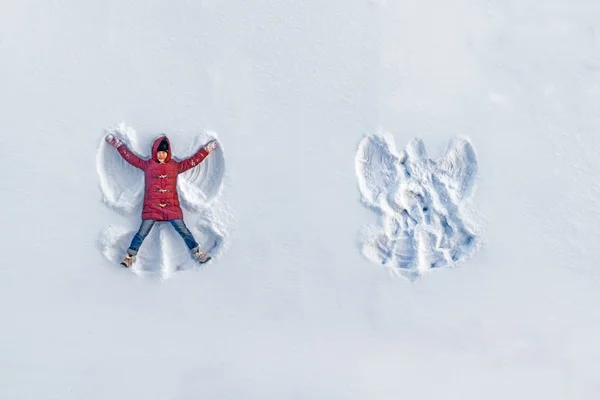 Girl shows snow angel — Stock Photo, Image