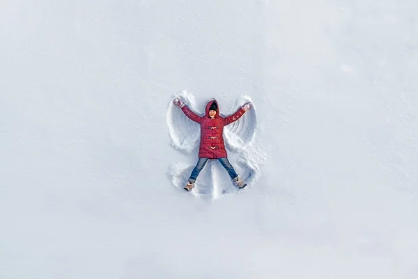 Dívka ukazuje sníh anděl — Stock fotografie