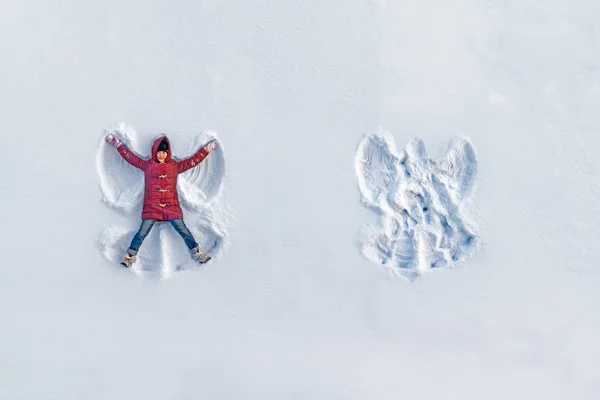 Κορίτσι δείχνει χιόνι άγγελος Εικόνα Αρχείου