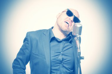 Tıraşsız kel adam mikrofon ile