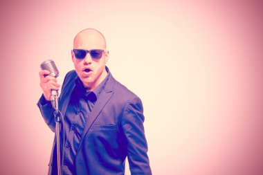 Tıraşsız kel adam mikrofon ile