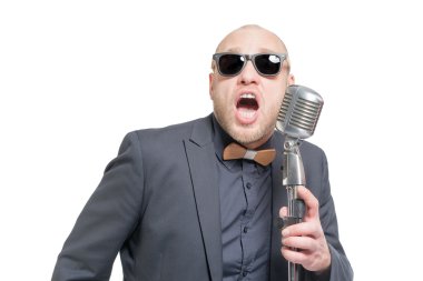 Tıraşsız kel adam mikrofon ile