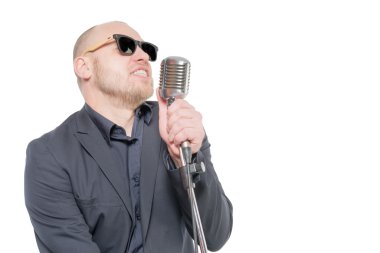 Tıraşsız kel adam mikrofon ile