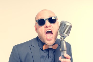 Tıraşsız kel adam mikrofon ile