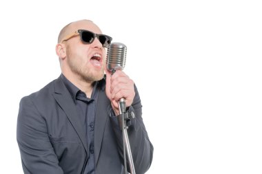 Tıraşsız kel adam mikrofon ile