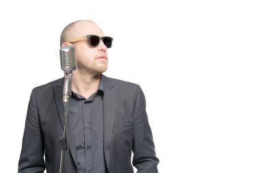 Tıraşsız kel adam mikrofon ile