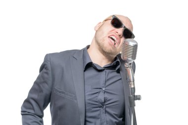 Tıraşsız kel adam mikrofon ile