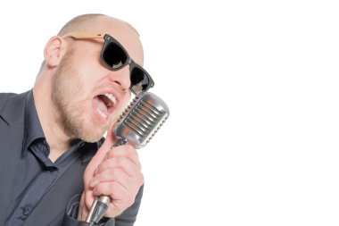 Tıraşsız kel adam mikrofon ile