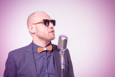 Tıraşsız kel adam mikrofon ile