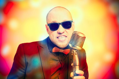 Tıraşsız kel adam mikrofon ile