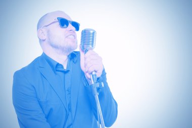 Tıraşsız kel adam mikrofon ile