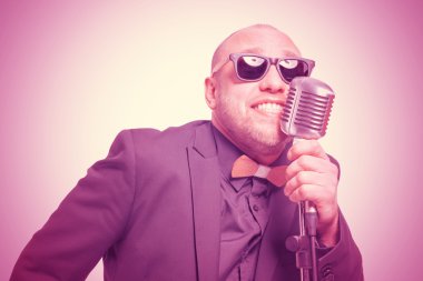 Tıraşsız kel adam mikrofon ile