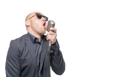 Tıraşsız kel adam mikrofon ile