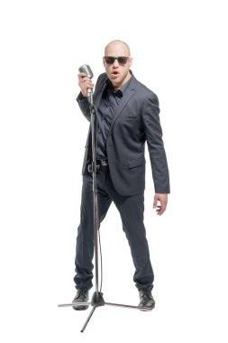 Tıraşsız kel adam mikrofon ile