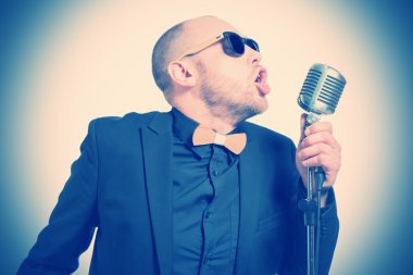 Tıraşsız kel adam mikrofon ile