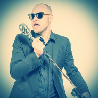 Tıraşsız kel adam mikrofon ile