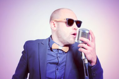 Tıraşsız kel adam mikrofon ile