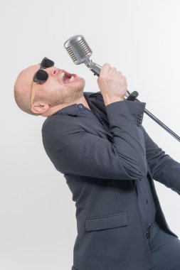 Tıraşsız kel adam mikrofon ile