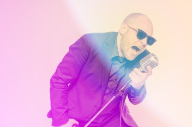 Tıraşsız kel adam mikrofon ile