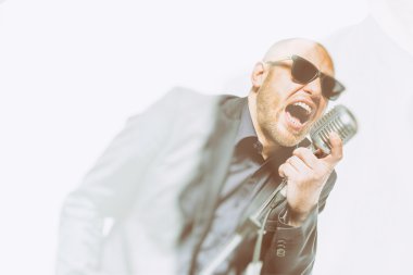 Tıraşsız kel adam mikrofon ile