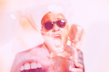 Tıraşsız kel adam mikrofon ile