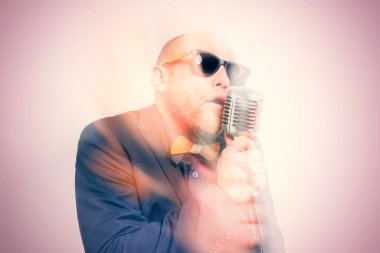 Tıraşsız kel adam mikrofon ile