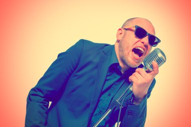 Tıraşsız kel adam mikrofon ile