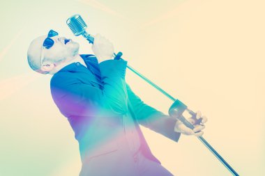 Tıraşsız kel adam mikrofon ile