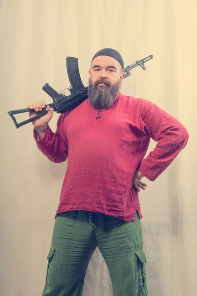 Бородатый человек с пистолетом — стоковое фото