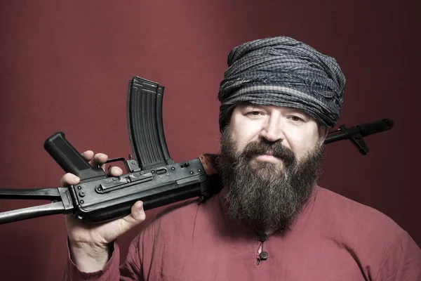 Бородатый человек с пистолетом — стоковое фото