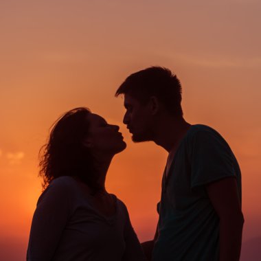 Genç çift sahilde günbatımı ayakta zevk.