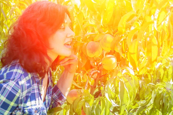 Молода жінка хоче їсти персик — стокове фото