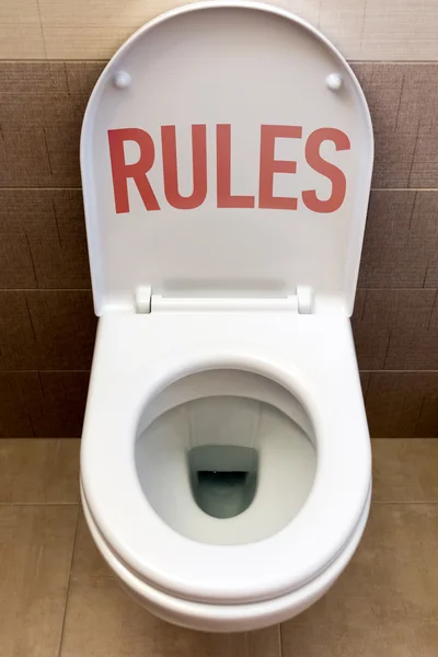 Toalett med en inskription "regler" — Stockfoto