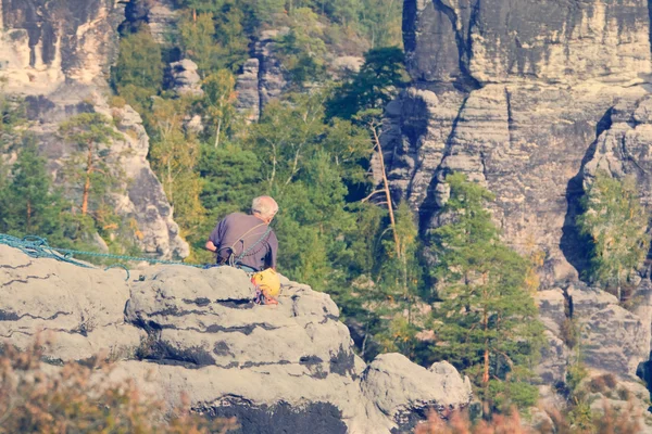 Сіроволоса людина сидить на скелі — стокове фото