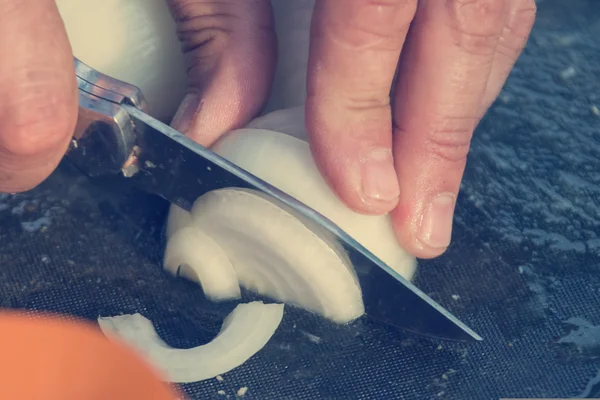 Mão cortar a cebola meias-anéis — Fotografia de Stock