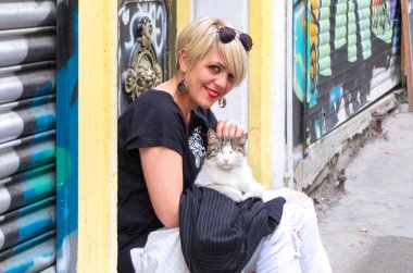 Kollarında bir kedi ile sarışın