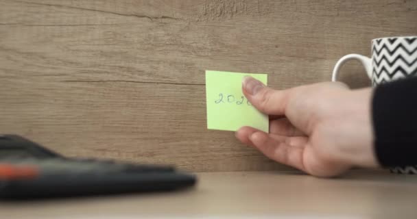 Man Klebt Einen Aufkleber Mit Der Aufschrift 2020 Die Wand — Stockvideo