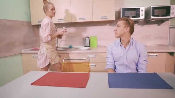 Young woman gives a glass of water to her husband — Stock Video