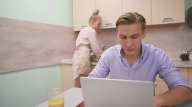 Önlüklü genç bir kadın lavaboda sebze yıkıyor.