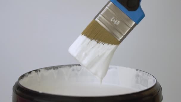 Hand Raises Brush Bucket Which White Paint Drips — Stock Video