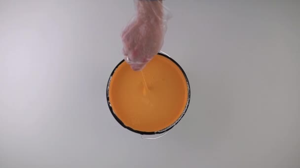 Arbetaren Börjar Röra Orange Färg För Att Måla Väggen — Stockvideo