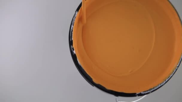 Рабочий Помешивающий Оранжевую Краску Ведро Камера Движется Рукой Рабочего — стоковое видео