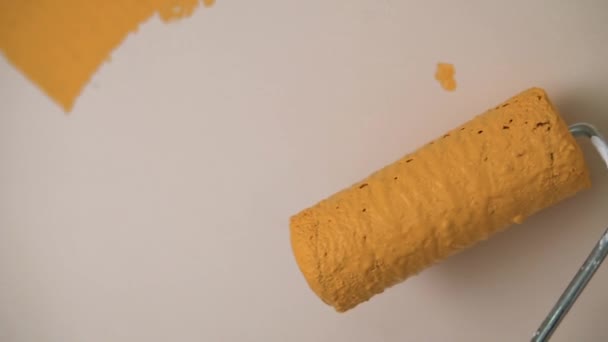 Eine Walze Mit Dicker Orangefarbener Farbe Rollt Der Wand Entlang — Stockvideo