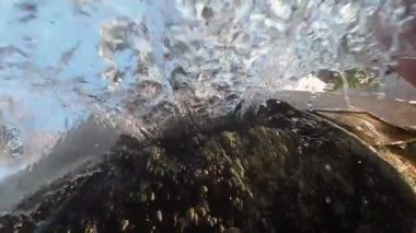 Su taştan aşağı akıyor. Şelale doğrudan kameraya akar. Suda çekim yapmak..
