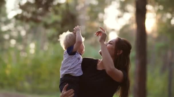 母は息子を腕の中に抱えて見上げさせる 幸せな家族だ 母と息子 — ストック動画