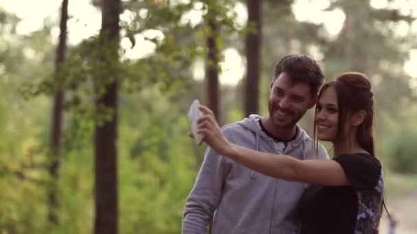 園内の電話で幸せな若者たちが自撮りをする 人を愛してる 公園を２人で歩きなさい 幸せな関係 — ストック動画