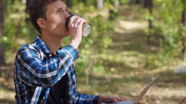 Ekose Gömlekli Adam Parkta Dizüstü Bilgisayarla Otururken Bir Yudum Kahve — Stok video