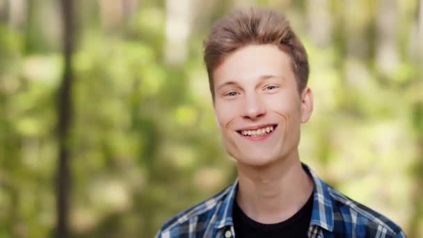 Mavi Ekose Gömlekli Genç Bir Adam Doğrudan Kameraya Bakıyor Gülümsüyor — Stok video