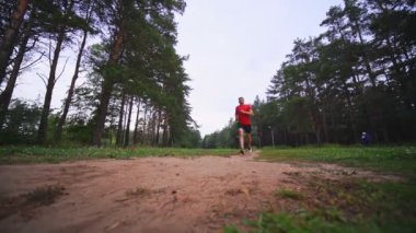 Sporcu parkta koşuyor. Ağır çekim. Açık hava sporları