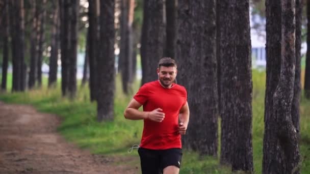 Homem Corre Floresta Ouvindo Música Fones Ouvido Movimento Lento Esportes — Vídeo de Stock